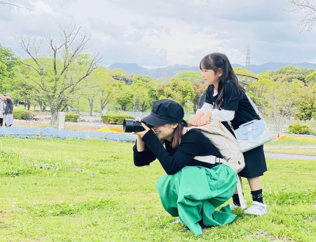 娘をおんぶして撮影するカメラマン時代のCoharu